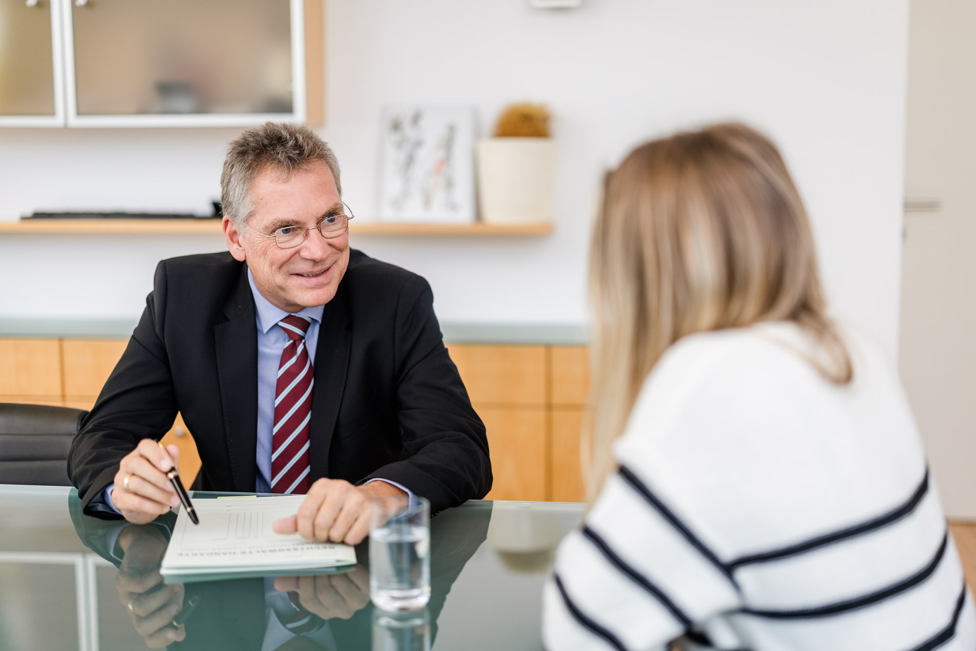 Nahaufnahme Anwalt der mit einer Frau am Tisch spricht.