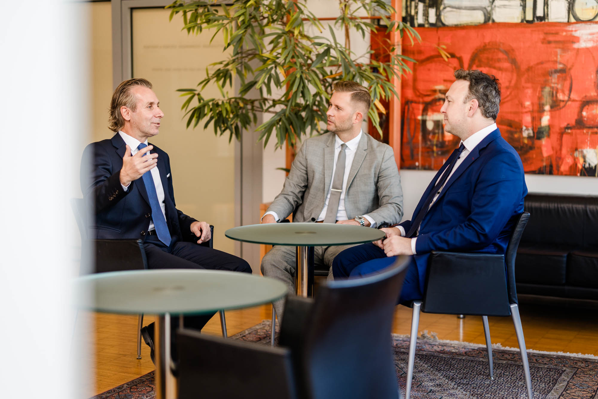 Drei Anwälte sitzen an einem Tisch und führen ein Gespräch