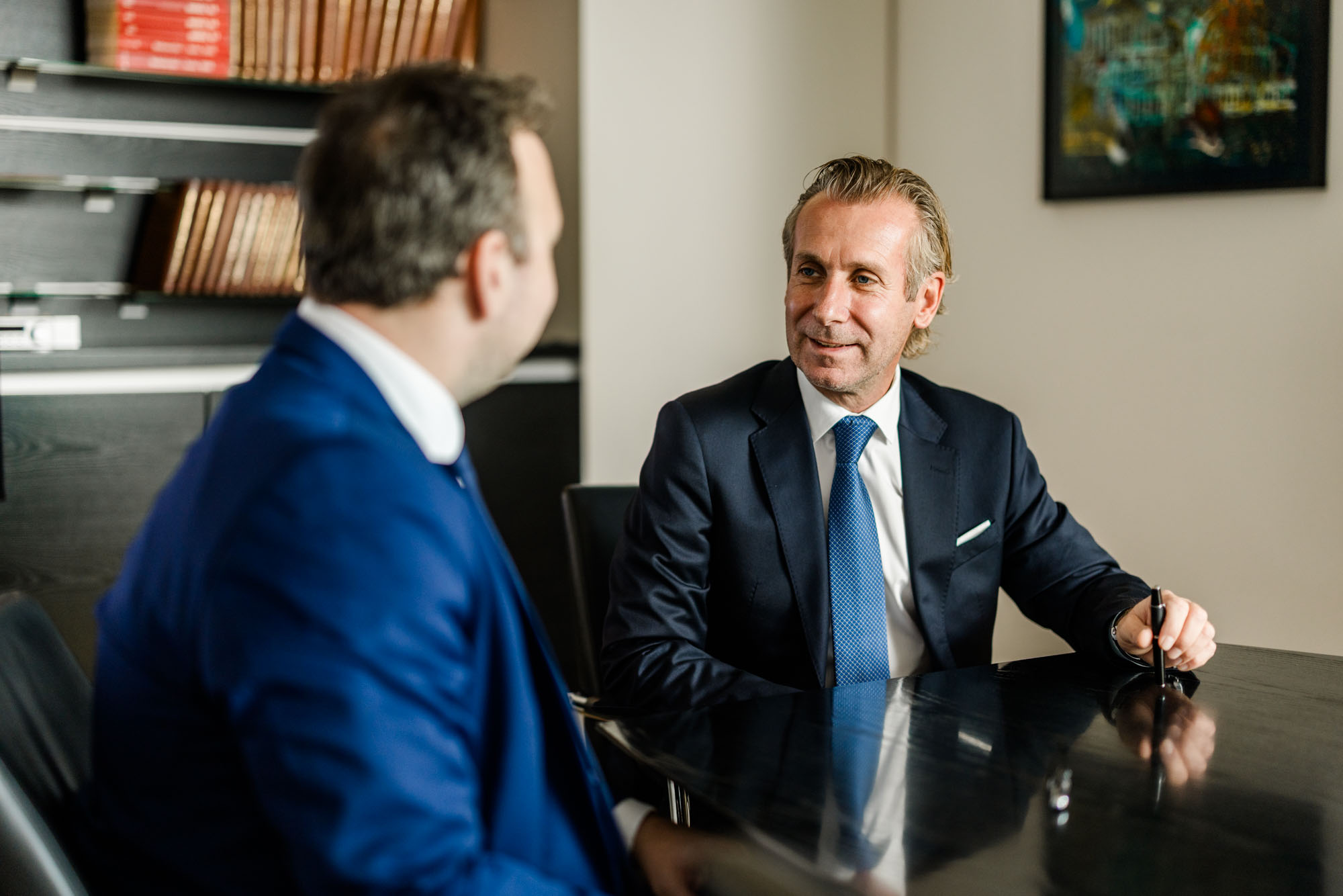 Zwei Anwälte sitzen sich gegenüber und sprechen miteinander.