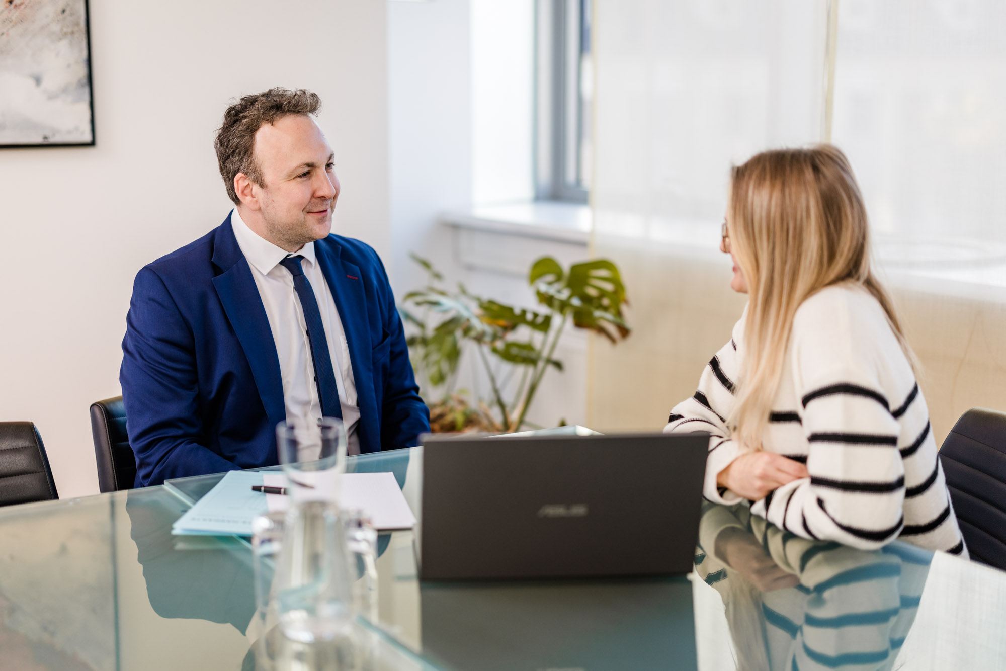 Anwalt spricht mit einer Frau am Tisch.