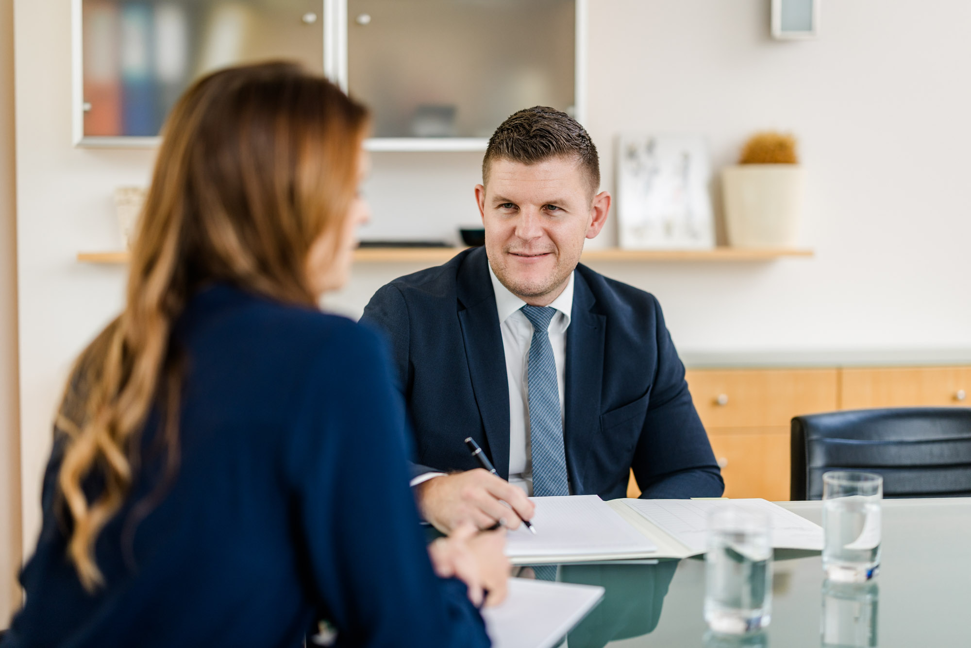 Anwalt spricht mit einer Frau an einem Tisch