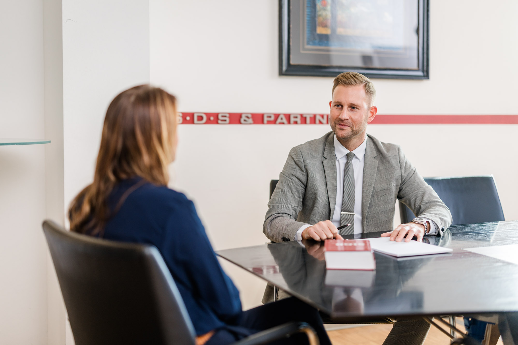 Anwalt sitzt gegenüber einer Frau bei einem Gespräch im Büro